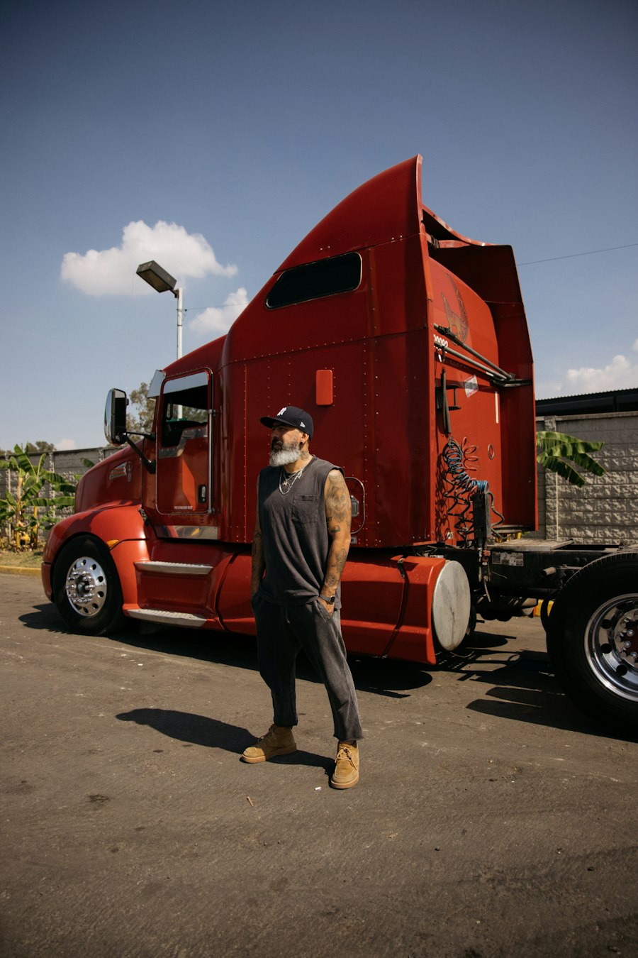 Truck driver standing in front of his red semi
